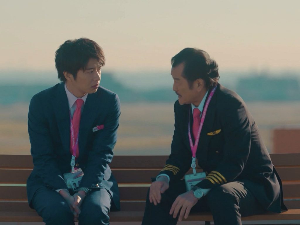 Characters from "Ossan's Love" sitting on a bench
