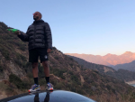 Zack Fox standing atop a car