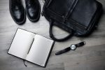 black formal shoes, black bag, watch on open planner on the floor in an article about starting your own business