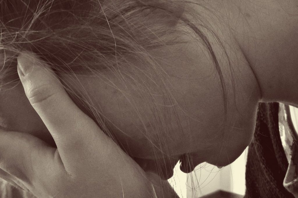 Picture of woman crying in an article about being quarantined in abusive households