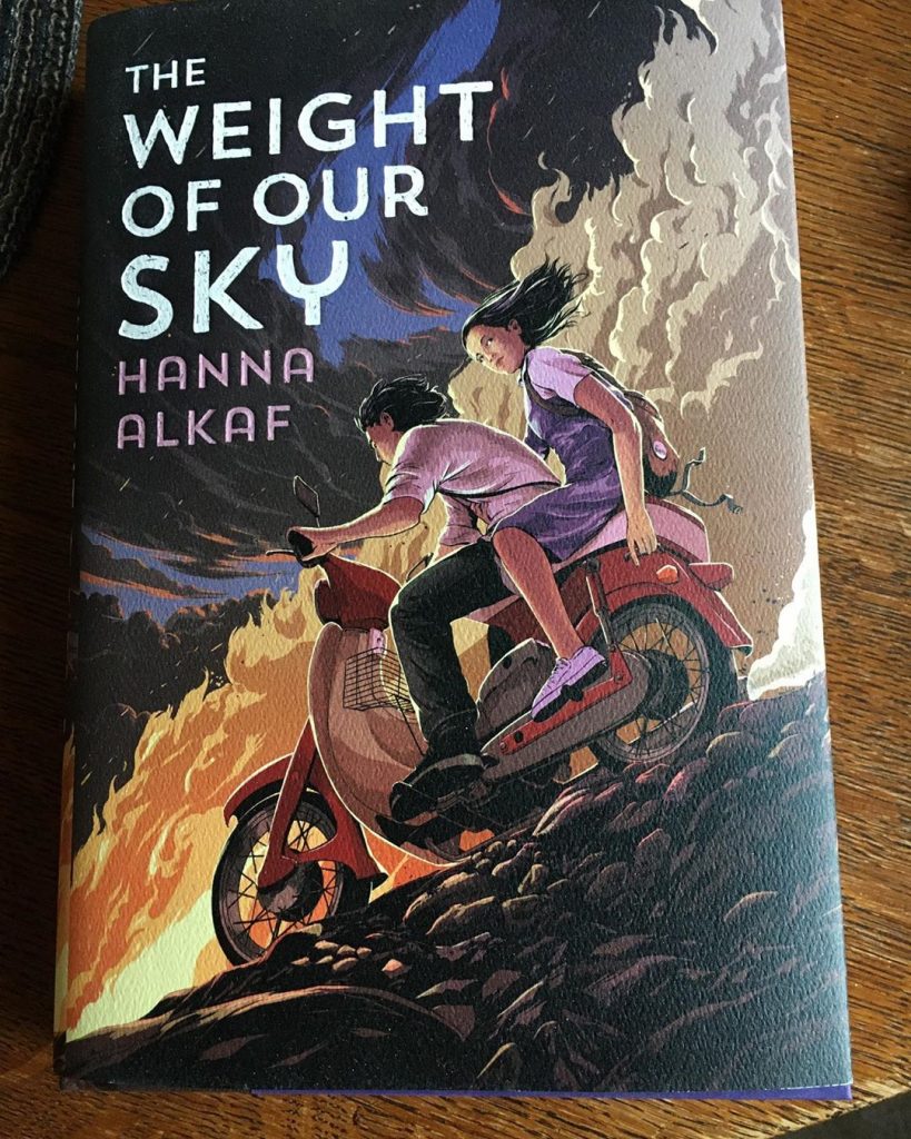 A copy of the YA novel The Weight of Our Sky