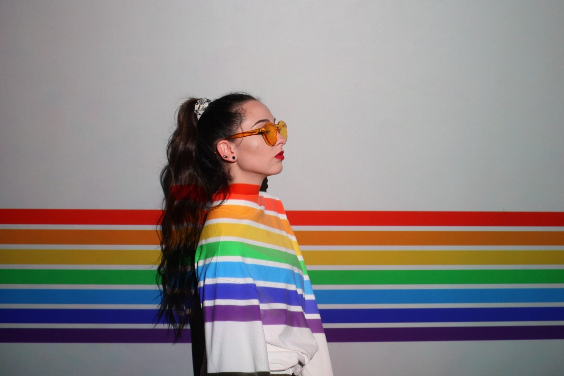 In an article about LGBTQ+ owned brands, a woman in a white shirt with rainbow stripes