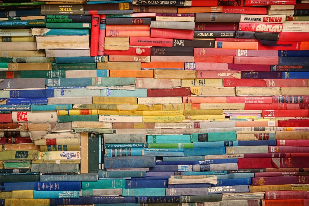 Writing for diversity: book spines arranged by color to resemble a rainbow.