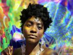 woman with natural hair against rainbow background