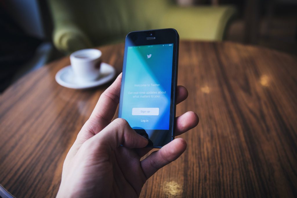 In an article about voice tweets and the Deaf community, a hand holding a phone with Twitter on it