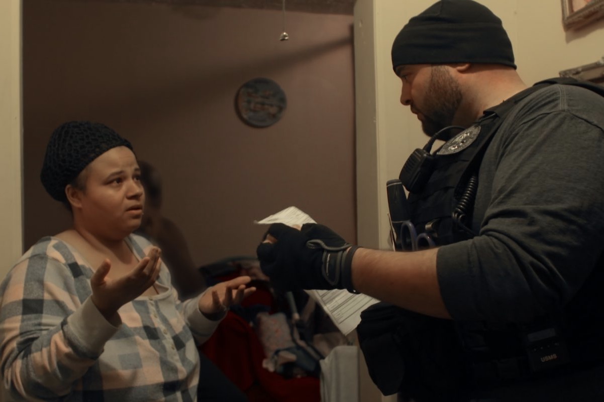 Image of a woman and a government agent in the docuseries Immigration Nation