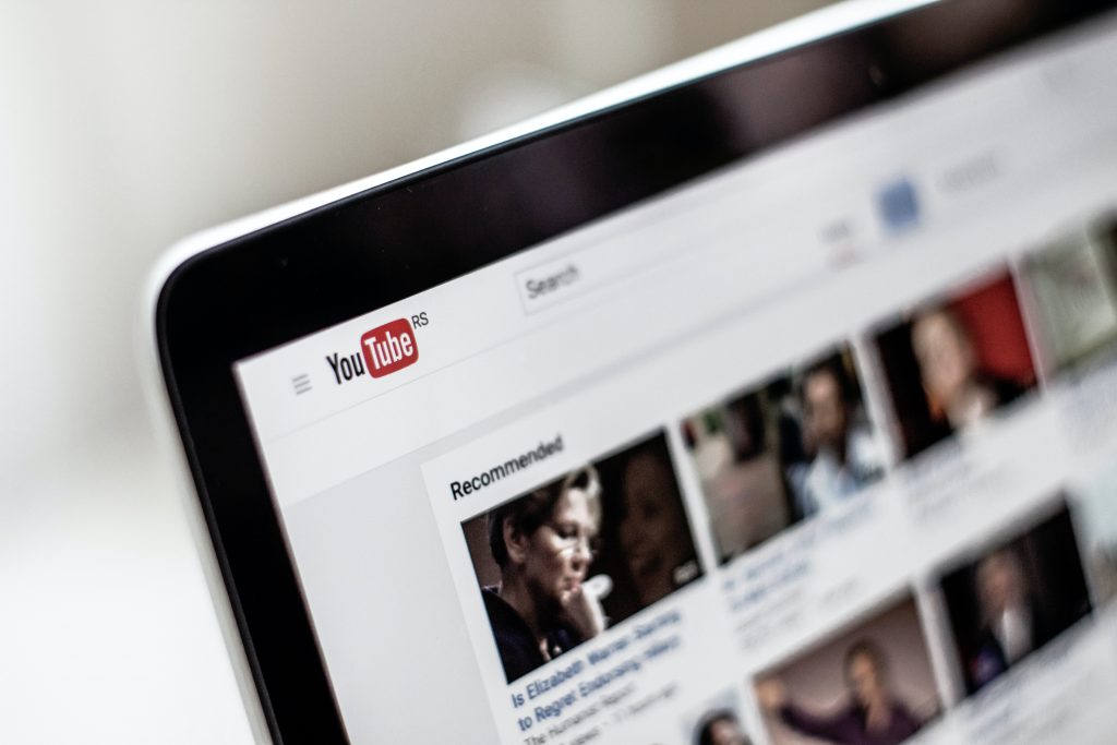 In an article about community captions, a photo of the YouTube home screen on a laptop