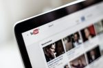In an article about community captions, a photo of the YouTube home screen on a laptop