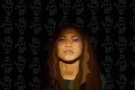 Zendaya from Euphoria in purple makeup against a black background