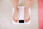 in an article about radical self acceptance, a person standing on a scale
