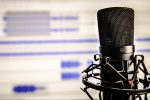 In an article about starting an actual play podcast, a microphone in front of a computer