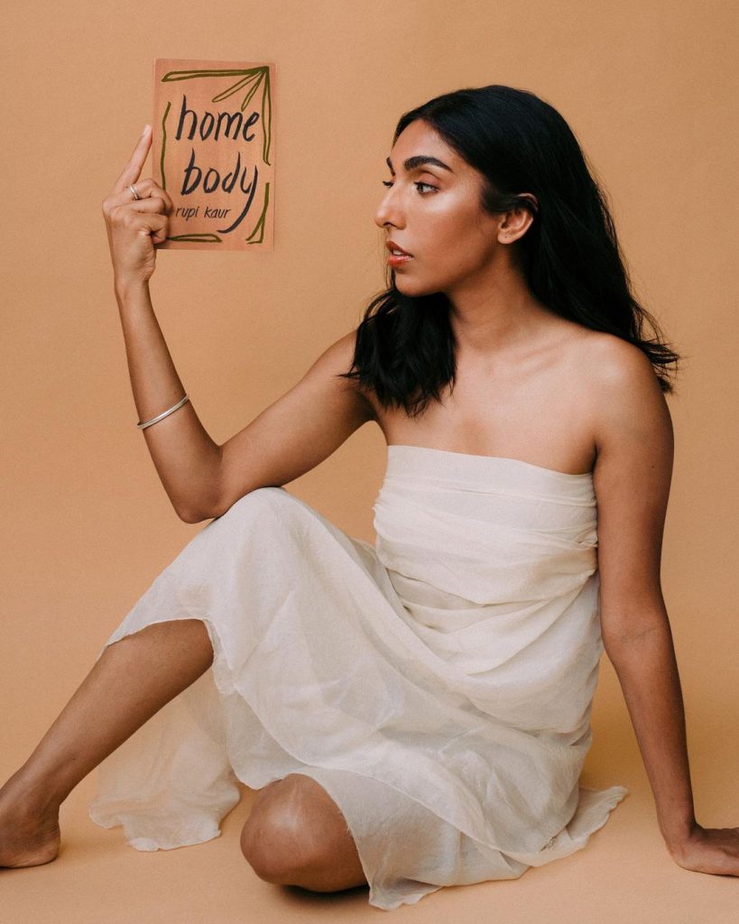 Rupi Kaur holding a copy of Home Body