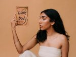 Rupi Kaur holding a copy of Home Body