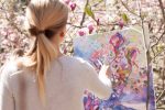 Photograph of a woman painting outside for an article about creative artists during the pandemic. (Photo by Tetiana Shyshkina from Unsplash)