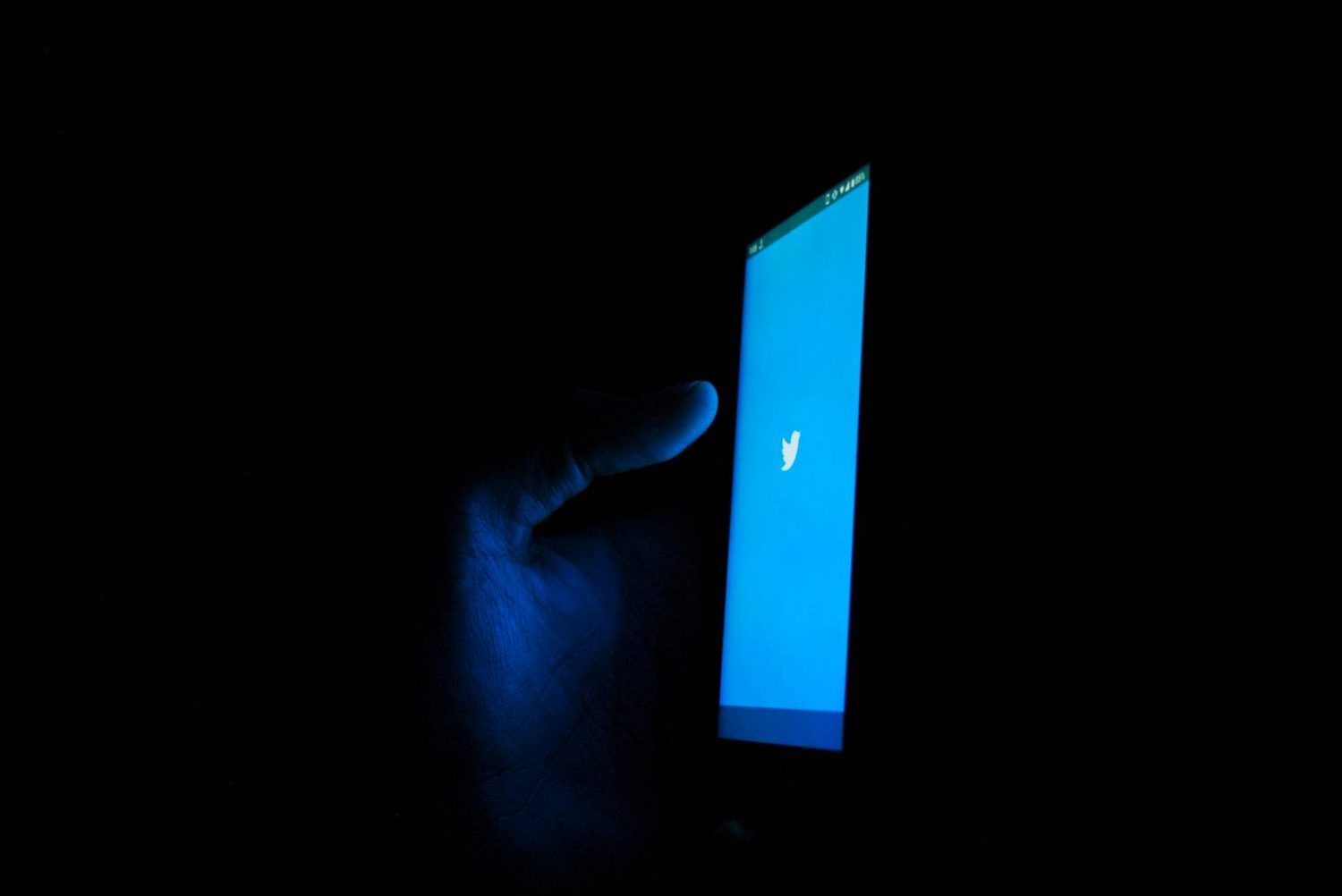 Photo of someone using Twitter in the dark