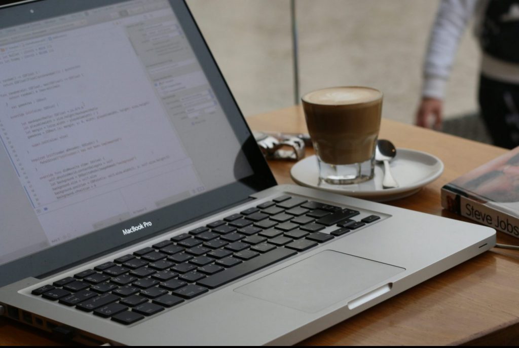 In an article about improving English grades, a computer with a cup of coffee next to it
