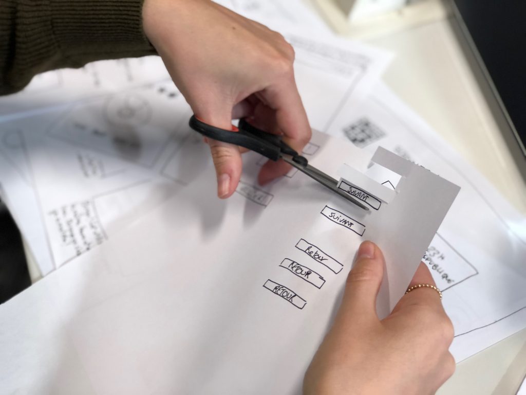 in an article about mockups, someone cutting paper with scissors