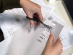 in an article about mockups, someone cutting paper with scissors