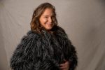 In an article about Facial Gua Sha, a person in an outfit with feathers