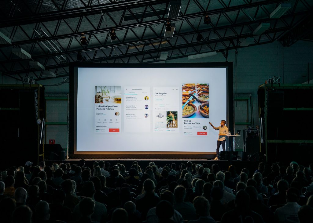 In an article about PowerPoint presentations, someone standing in front of a presentation screen
