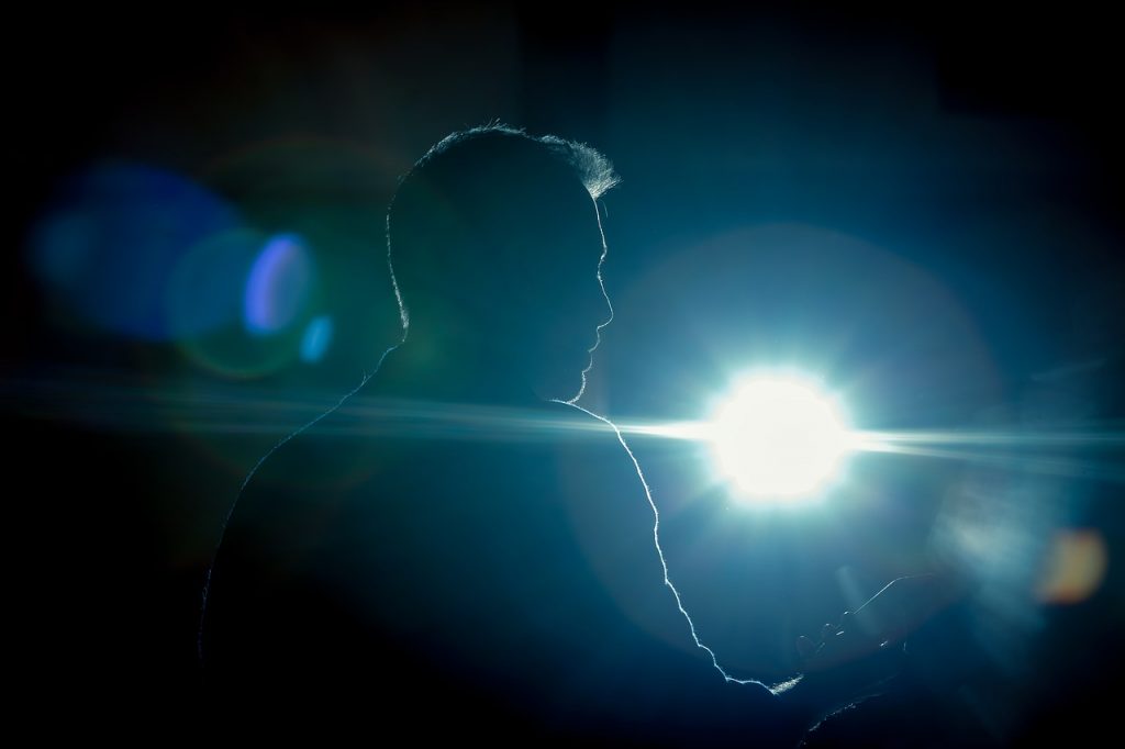 An image of an actor in front of a spotlight