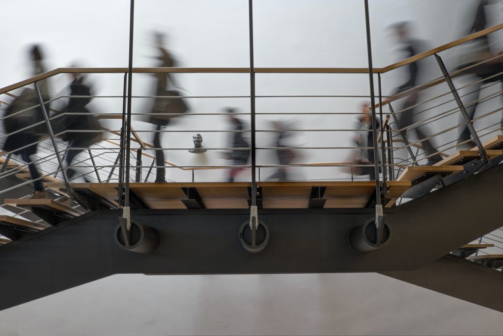 in article about seniors in college, a blurry photo of students walking on a walkway