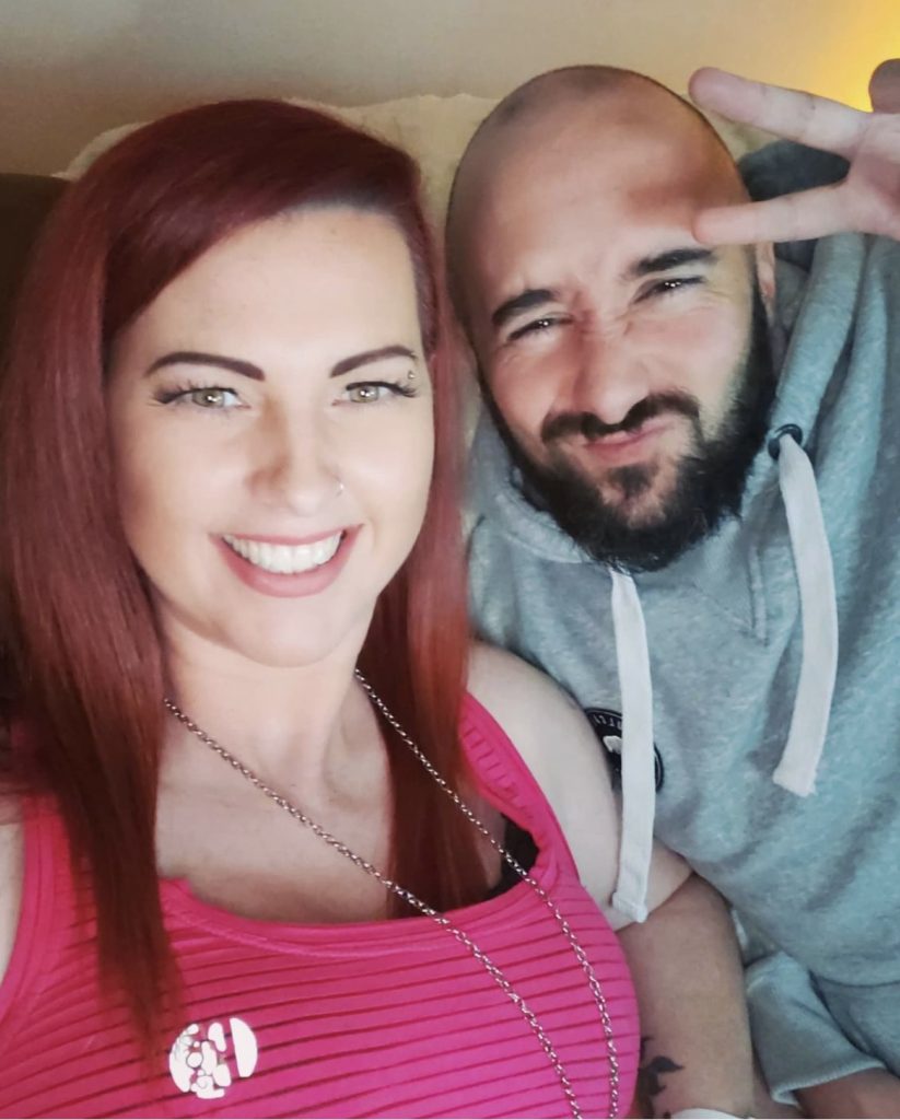 Influencers HeyKimAndTyler pose for an Instagram photo, Kim smiling and Tyler throwing up a peace sign.