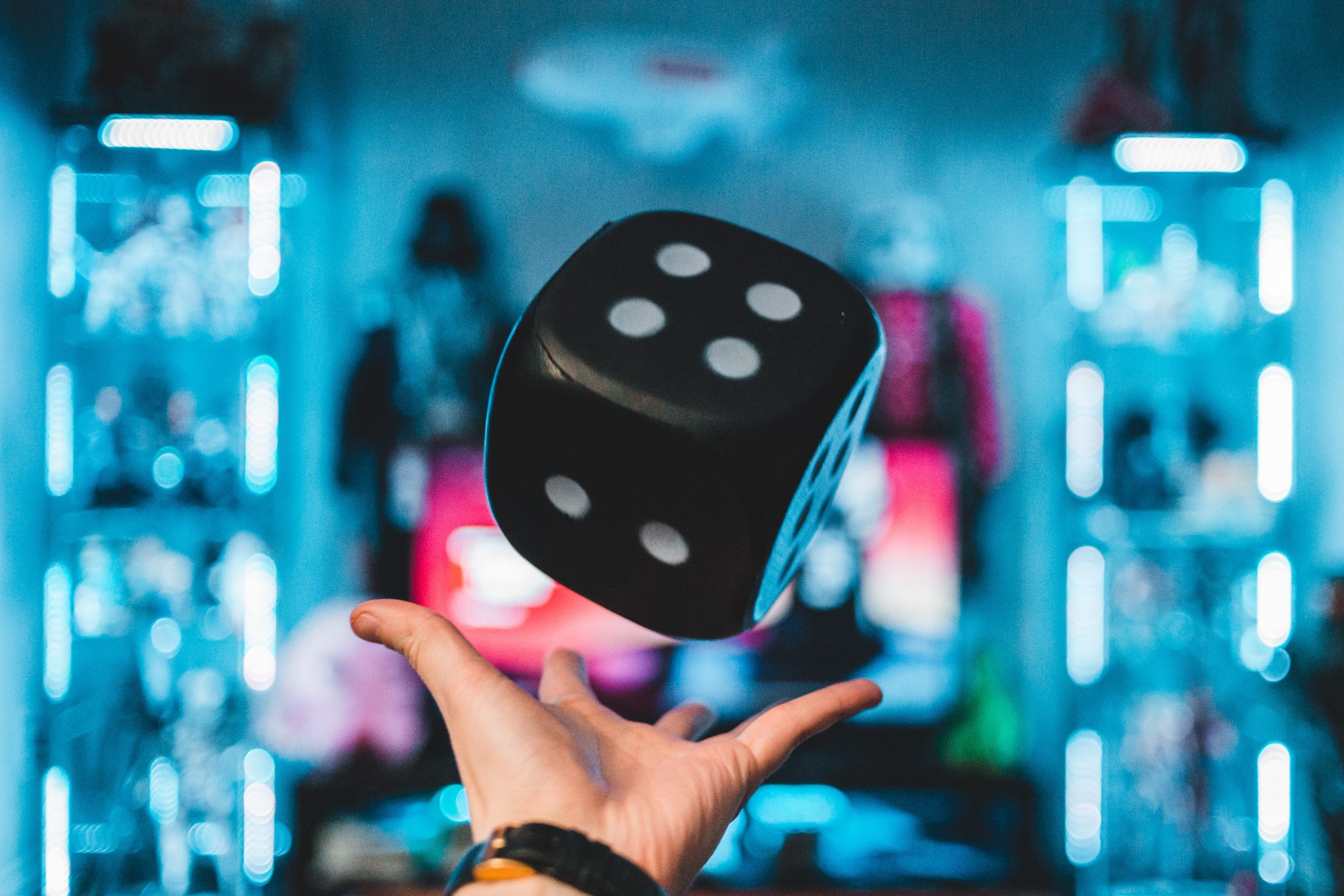 in article about licensed gambling operators, a hand throwing up an oversized dice