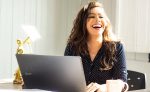 in article about paying off a student loan, a person laughing at a laptop