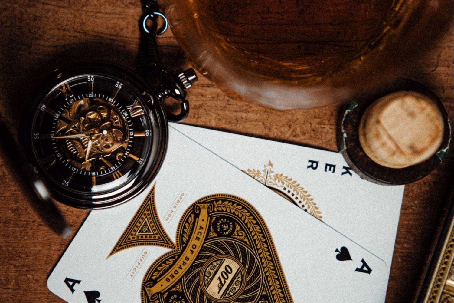 in article about online casinos, an ace of spades and a joker card next to a compass and an ash tray