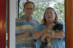 Main characters Bridget and Joel from the new series Somebody Somewhere stand in doorway with a dog.