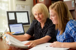 professors and student looking at a paper together