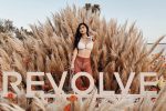 influencer posing behind the revolve fest sign