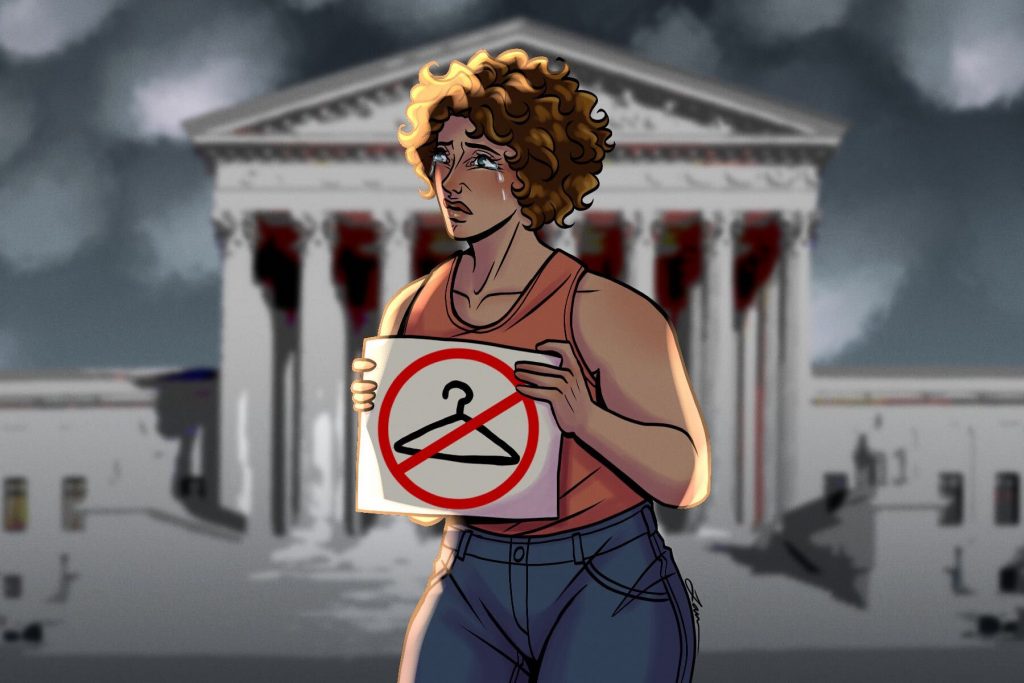 A woman holding a sign with a clothes hanger on it, protesting the rights to abortion during The Summer of Rage.