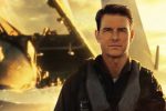 A screenshot from Top Gun: Maverick shows Tom Cruise with a plane in the background