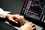 in article about forex, someone on their laptop with line graphs on the screen