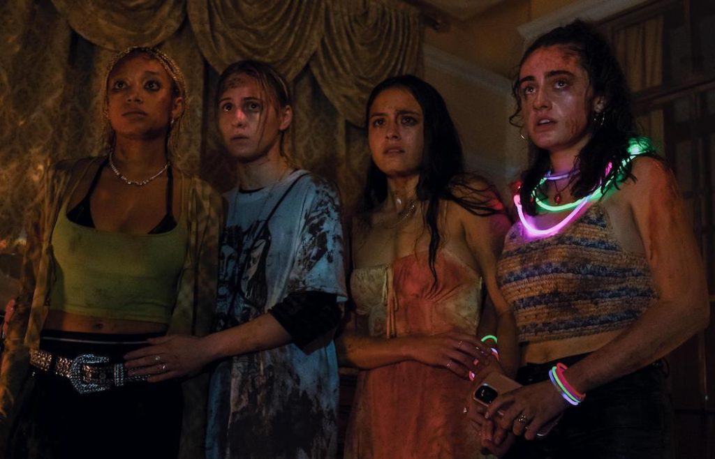 A screenshot from bodies bodies bodies shows three main characters staring with fear