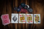 in an article about the online casino, four cards face up on a table next to some poker chips