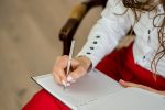 photo of a person writing an essay in a notebook