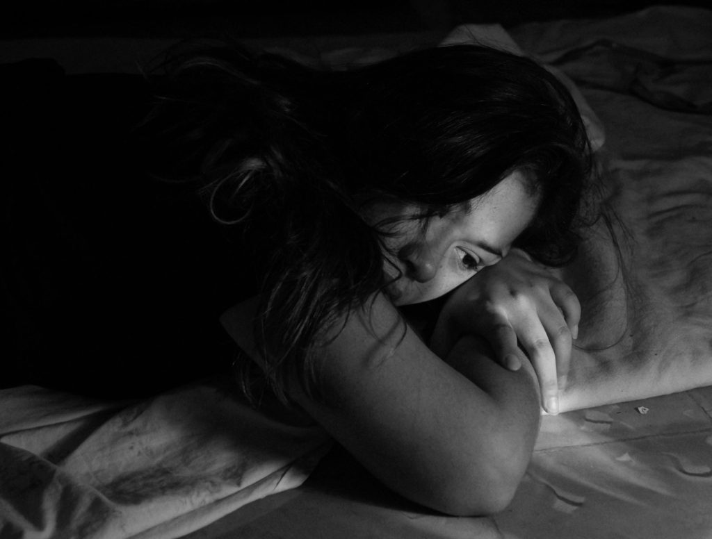 In an article about corporal punishment, a young girl lies down sadly