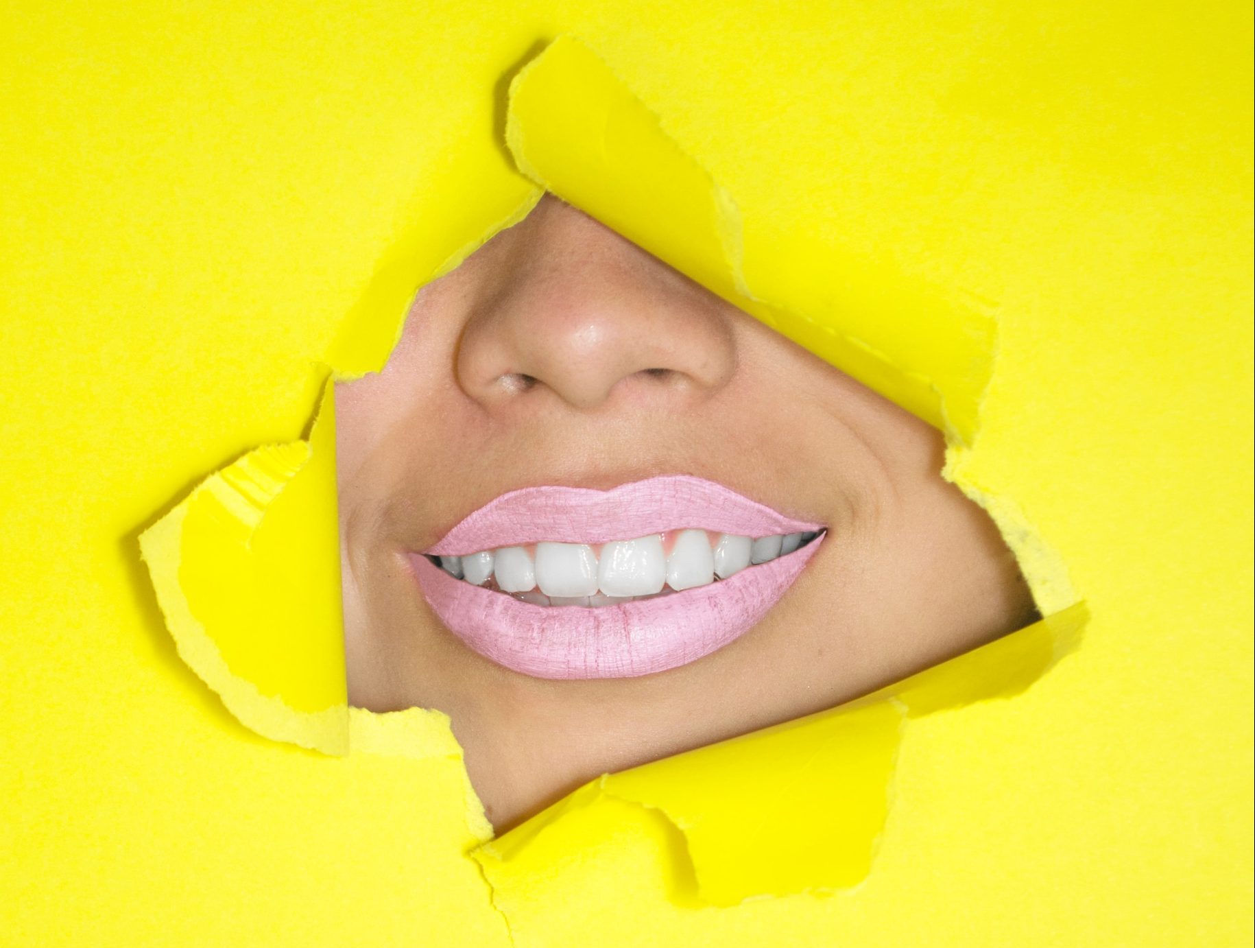 A toothy smile against a yellow backdrop