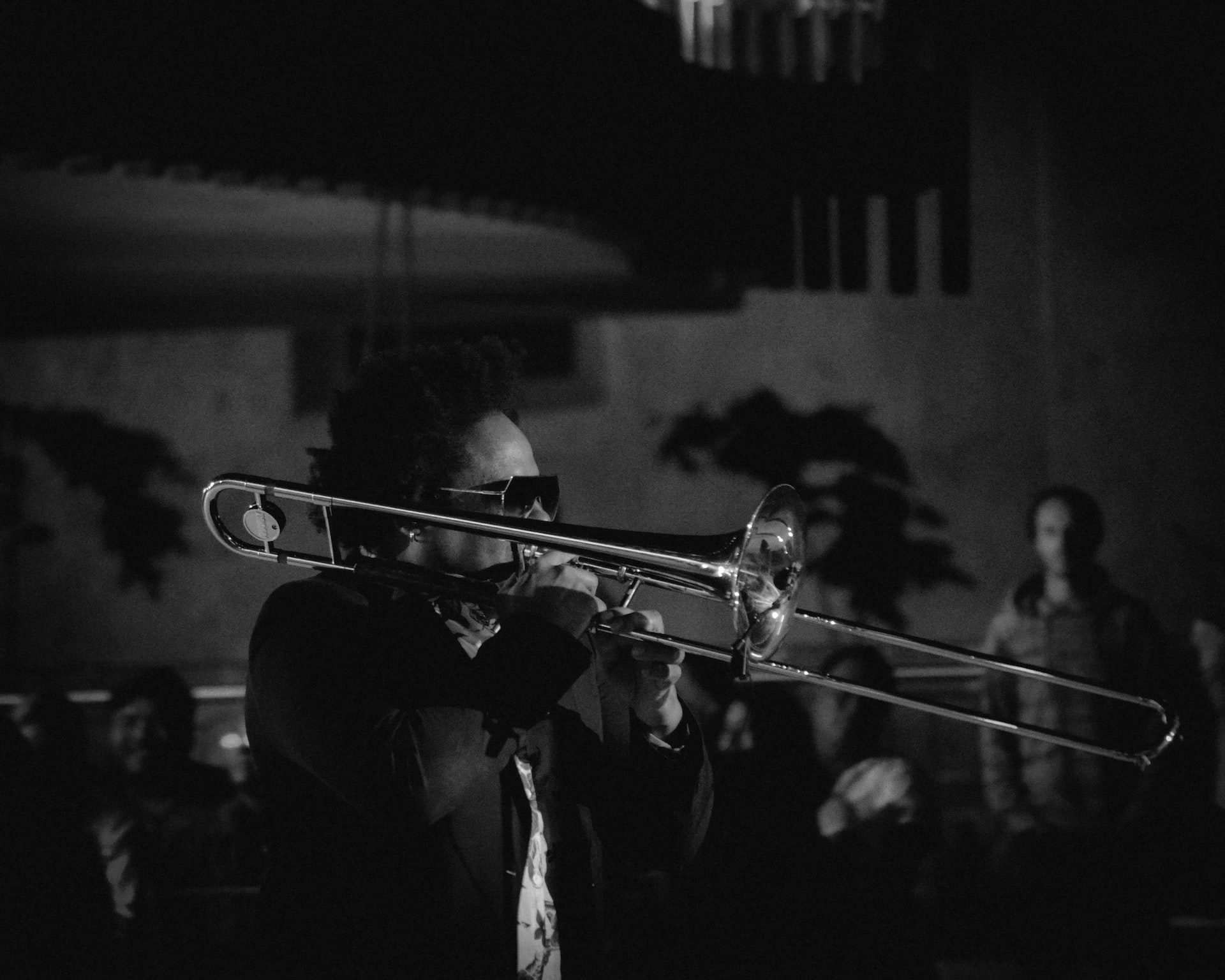 in article about kamasi washington, black-and-white image of a man playing the trombone