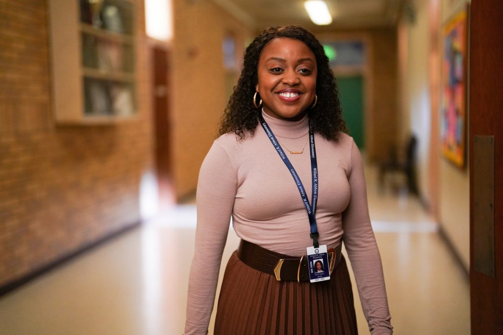 In an article about the achievements of Quinta Brunson, the actress stands in a school hallway in an episode of her hit TV show 'Abbott Elementary.'