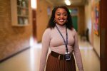 In an article about the achievements of Quinta Brunson, the actress stands in a school hallway in an episode of her hit TV show 'Abbott Elementary.'