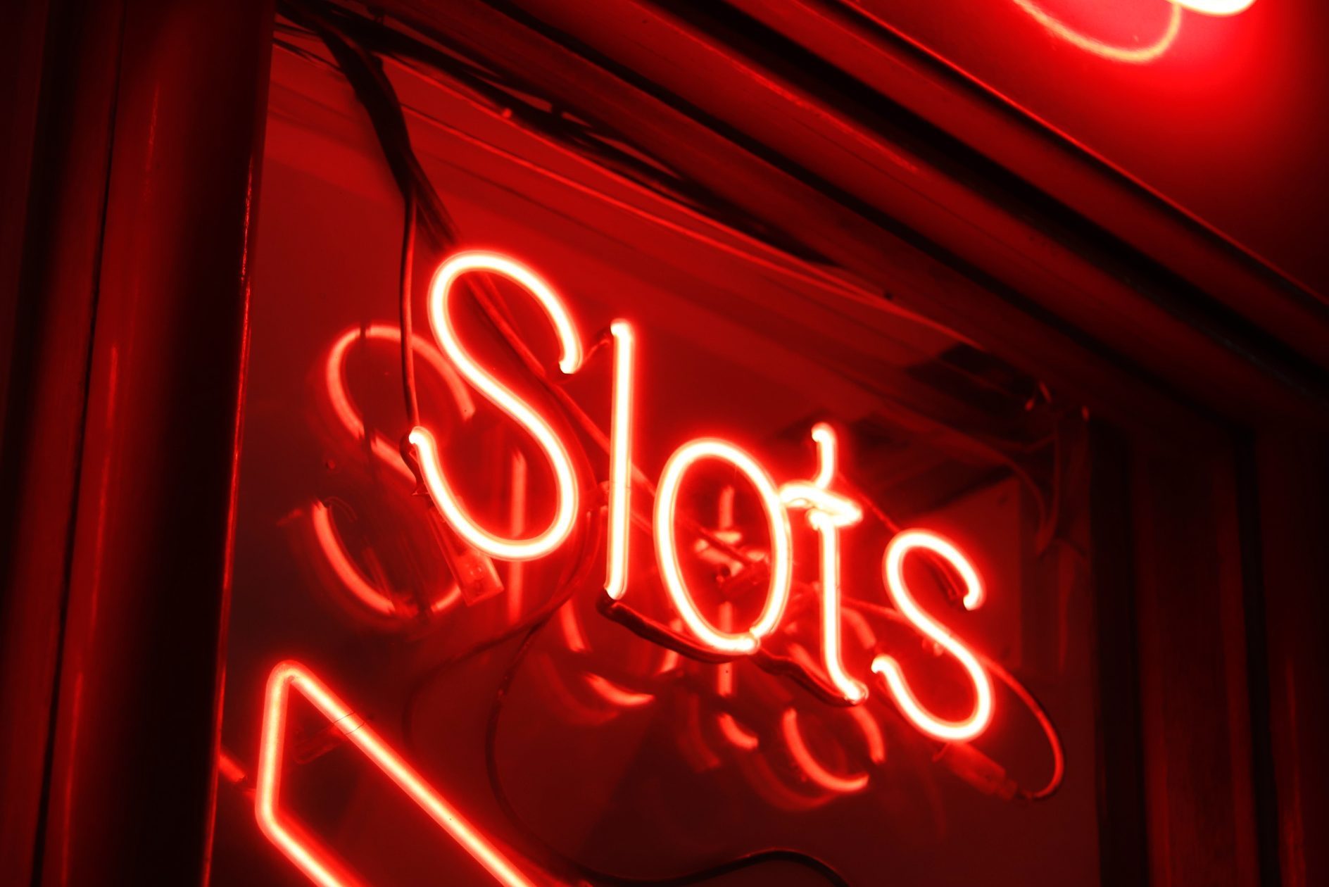 A red neon sign that reads "slots."
