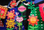 In an article about words in other languages that have no direct english translations, a field of paper flowers emblazoned with the word 'goodbye' in various languages sits against a black background.