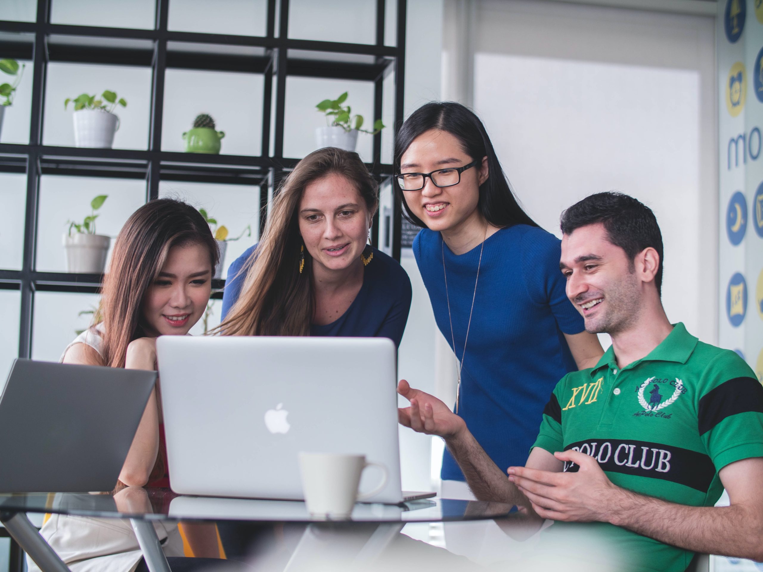 In an article about sweepstakes casinos four people look at a laptop.
