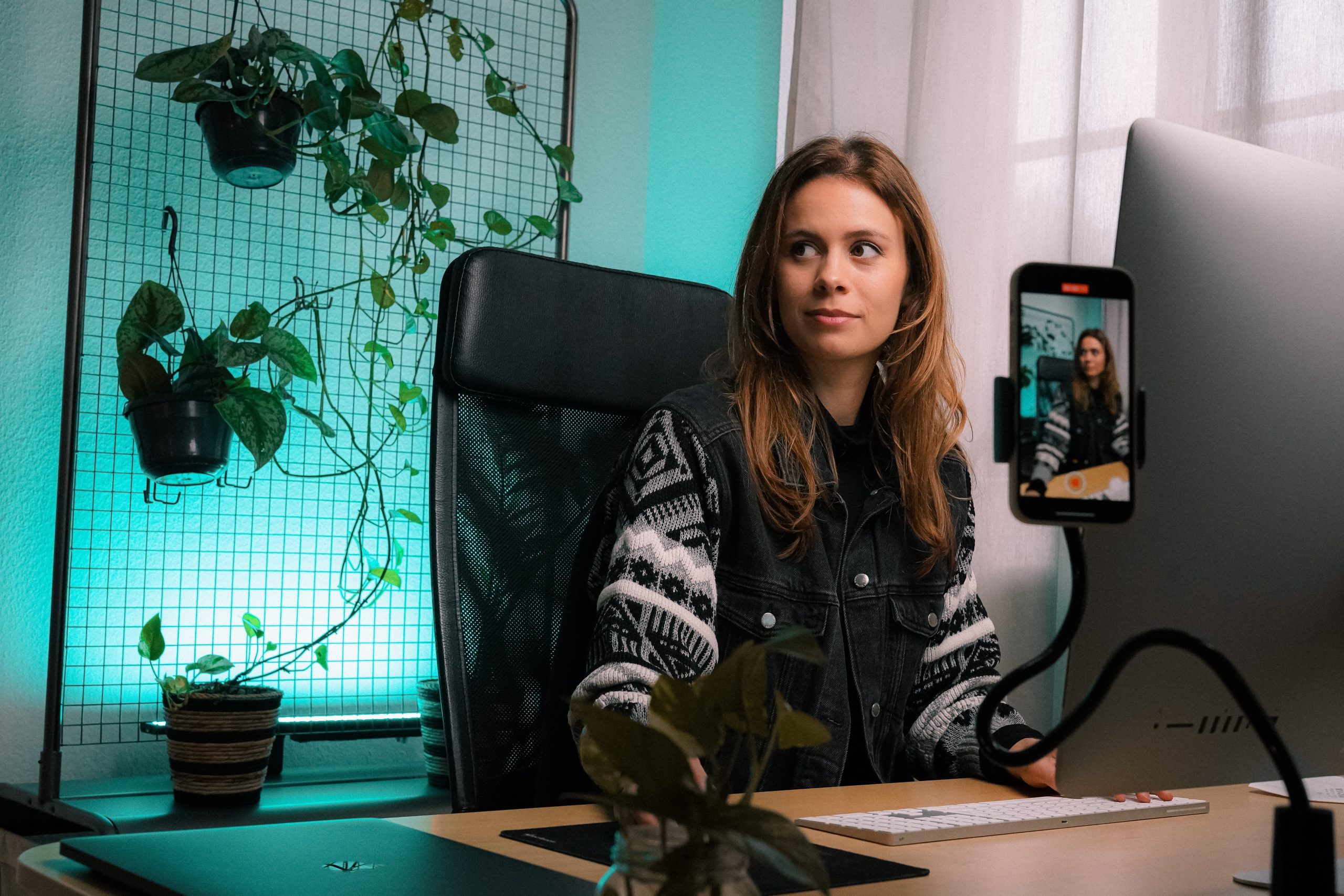 In an article about becoming a content creator, a woman sits at her desk and records a video.