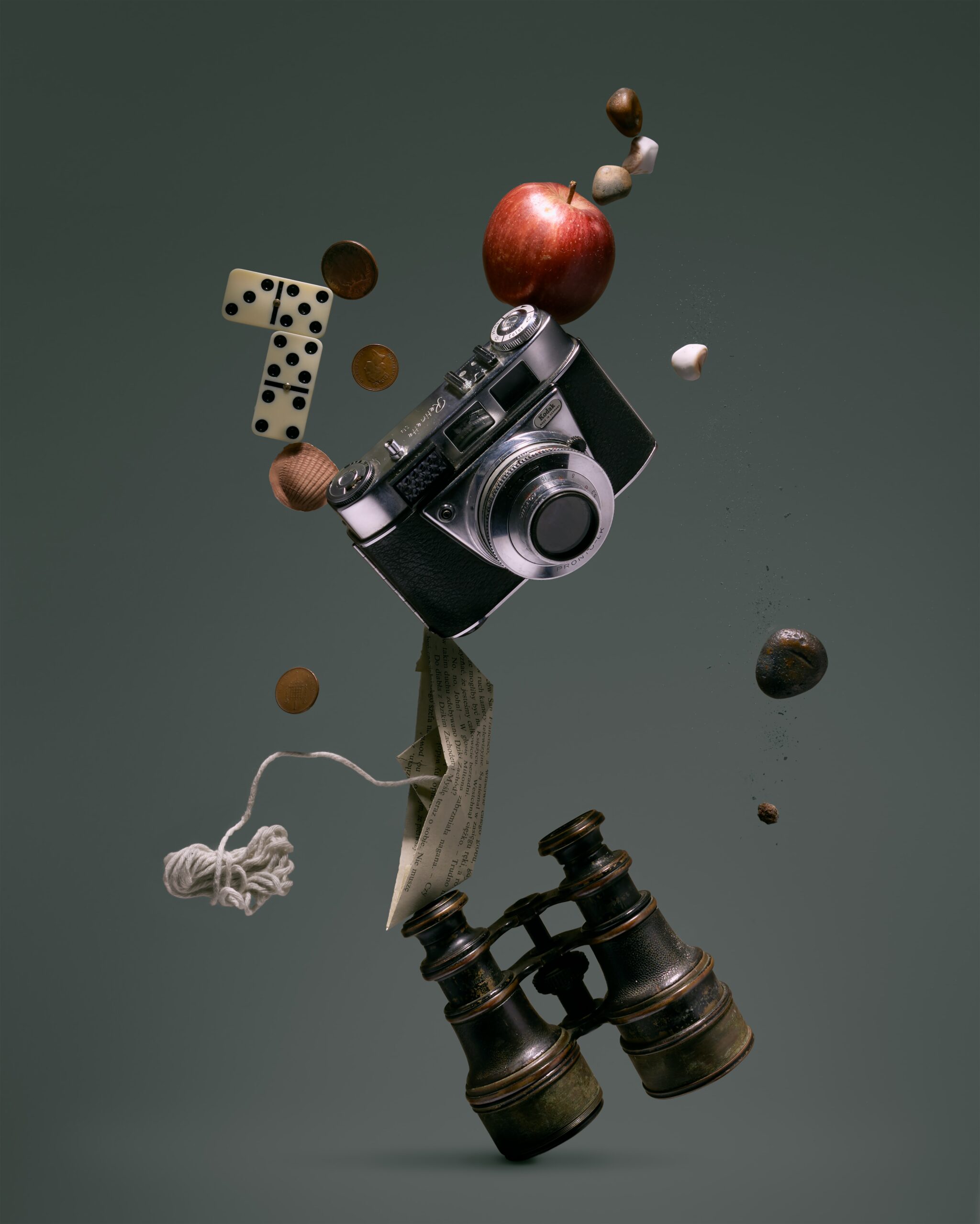 In an article about the Law of Assumption, distinct objects—an apple, a camera, a pair of binoculars, etc.— are balanced on top of one another.