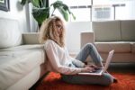 Girl leaning on coach with laptop